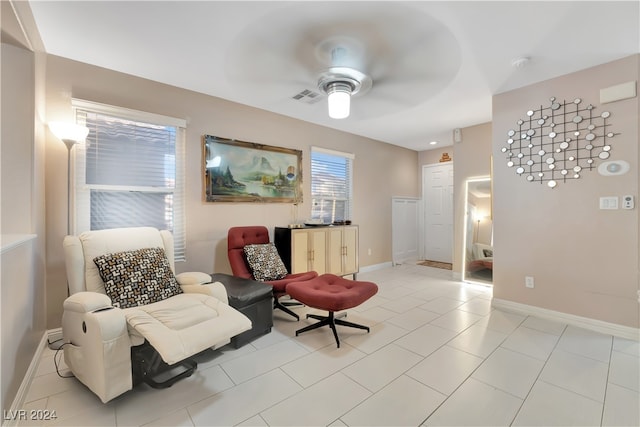 living area featuring ceiling fan and light tile patterned floors