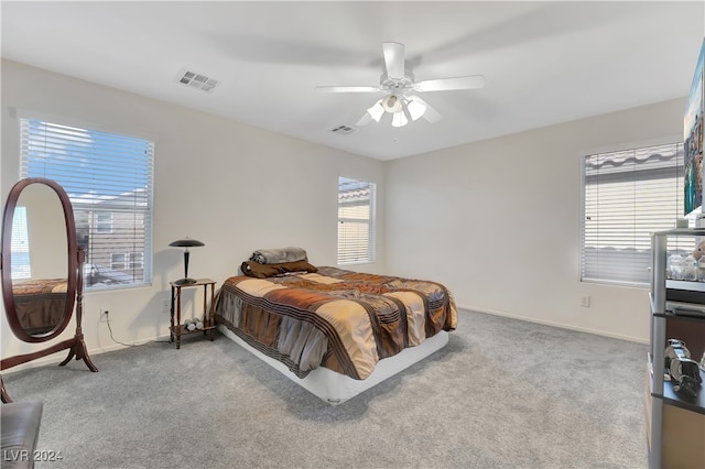 carpeted bedroom with multiple windows and ceiling fan