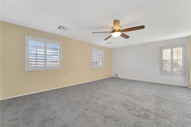 carpeted spare room with ceiling fan and a wealth of natural light