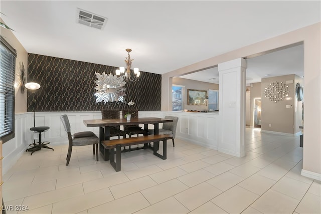 tiled dining space with ornate columns and an inviting chandelier