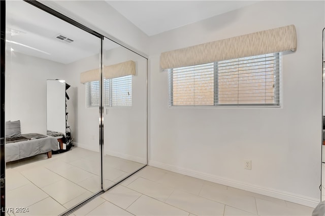 unfurnished bedroom with tile patterned flooring and a closet