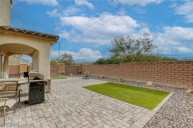 view of patio with grilling area and a fenced backyard