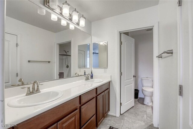 bathroom featuring tile patterned floors, vanity, a shower with shower door, and toilet