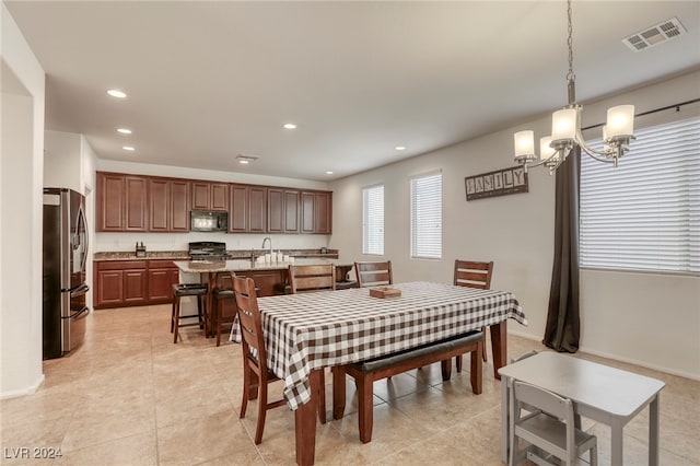 tiled dining space featuring a notable chandelier and sink