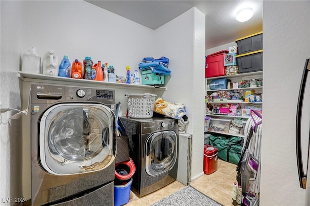 laundry room with tile patterned floors, washing machine and dryer, and laundry area