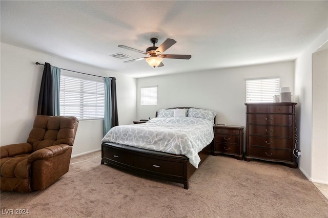 carpeted bedroom with visible vents, baseboards, and ceiling fan