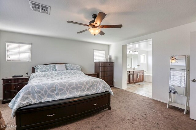 carpeted bedroom featuring ensuite bathroom and ceiling fan