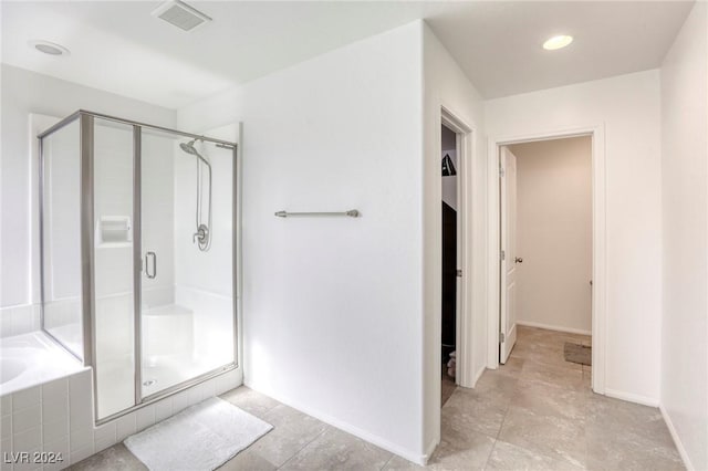 bathroom with a bath, baseboards, visible vents, and a stall shower