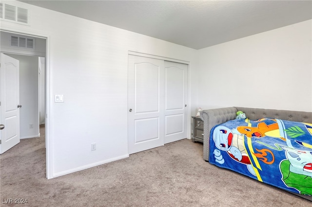 bedroom with light carpet and a closet