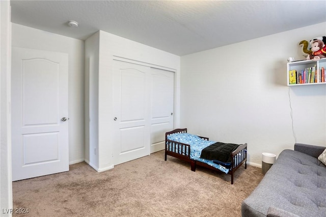 bedroom with baseboards, carpet floors, and a closet