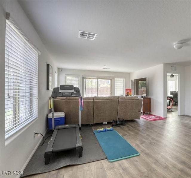 workout room featuring wood finished floors, visible vents, and baseboards