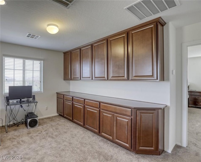 office featuring light carpet, visible vents, and baseboards