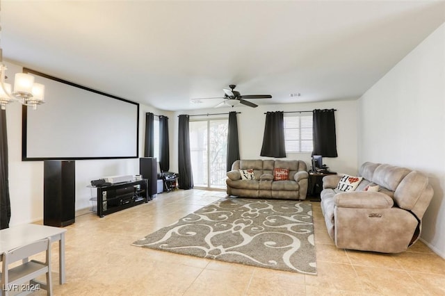 living area featuring tile patterned flooring, visible vents, and ceiling fan with notable chandelier