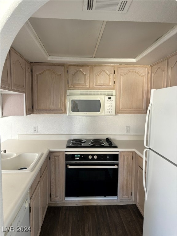 kitchen with light brown cabinetry and white appliances