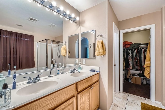 bathroom featuring vanity, a shower with door, and tile patterned flooring