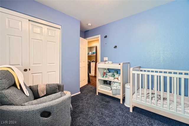 bedroom with dark colored carpet, a closet, and a crib