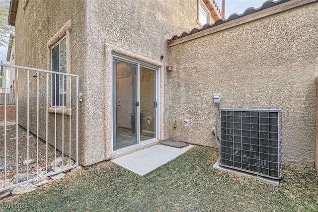 view of property exterior with cooling unit and a lawn