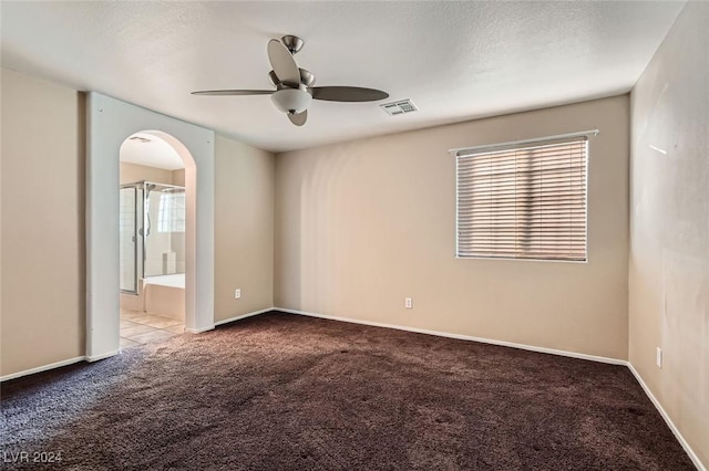 empty room featuring ceiling fan and carpet