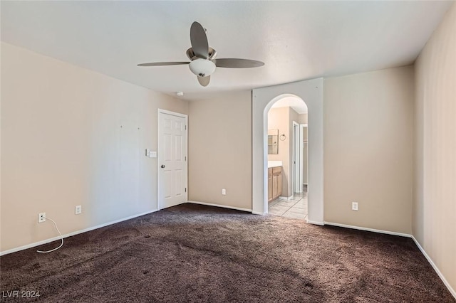 carpeted spare room featuring ceiling fan