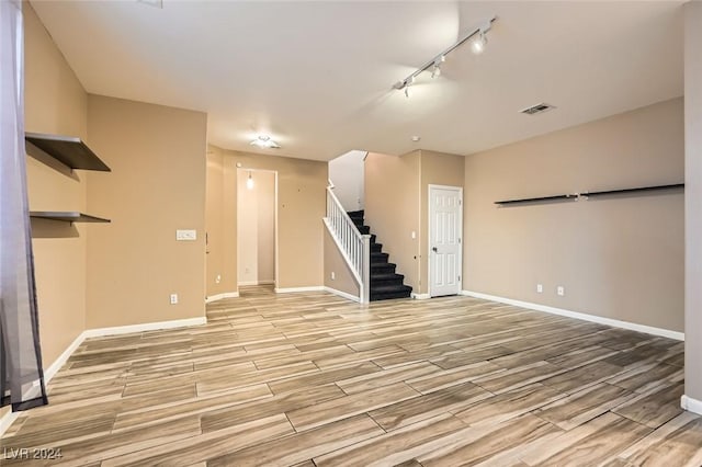 unfurnished living room featuring track lighting