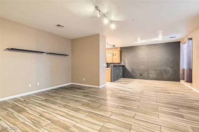 unfurnished living room with rail lighting