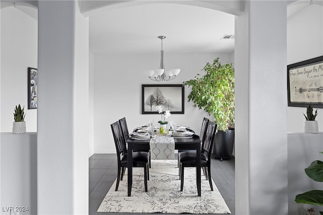 tiled dining room with a chandelier