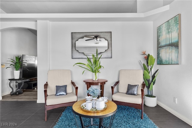 living area featuring ceiling fan and dark wood-type flooring