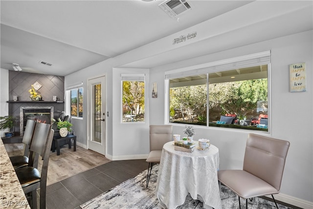 dining space featuring dark hardwood / wood-style floors and a high end fireplace