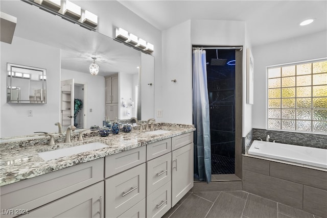 bathroom featuring tile patterned flooring, vanity, and shower with separate bathtub