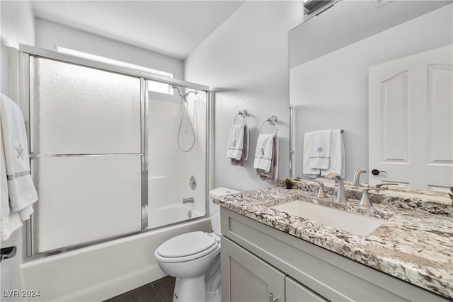 full bathroom with shower / bath combination with glass door, vanity, and toilet