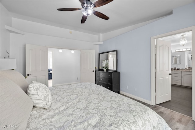 bedroom with ensuite bath, ceiling fan, and hardwood / wood-style flooring