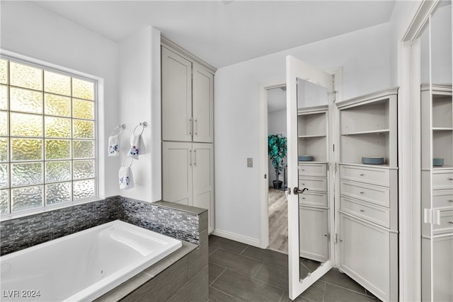 bathroom with tiled bath and tile patterned flooring