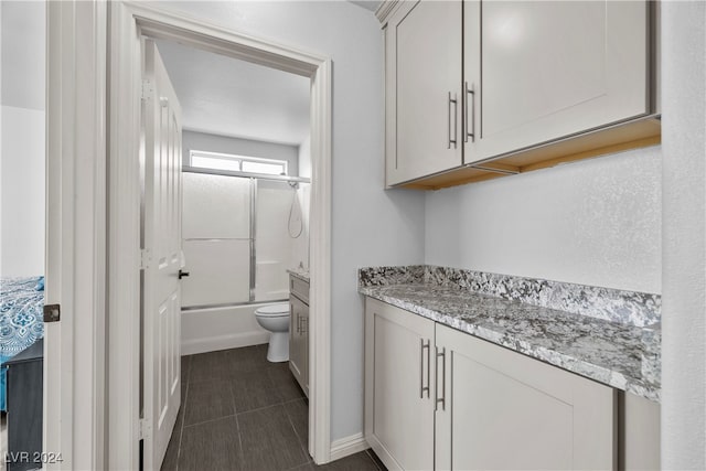 full bathroom with vanity, toilet, and enclosed tub / shower combo