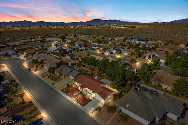 aerial view at dusk featuring a mountain view