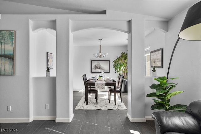 tiled dining area with a chandelier and lofted ceiling