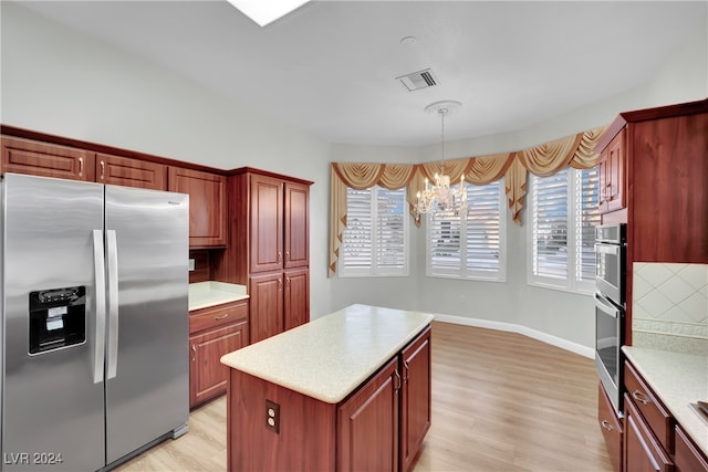 kitchen featuring light wood-type flooring, stainless steel appliances, a kitchen island, and plenty of natural light