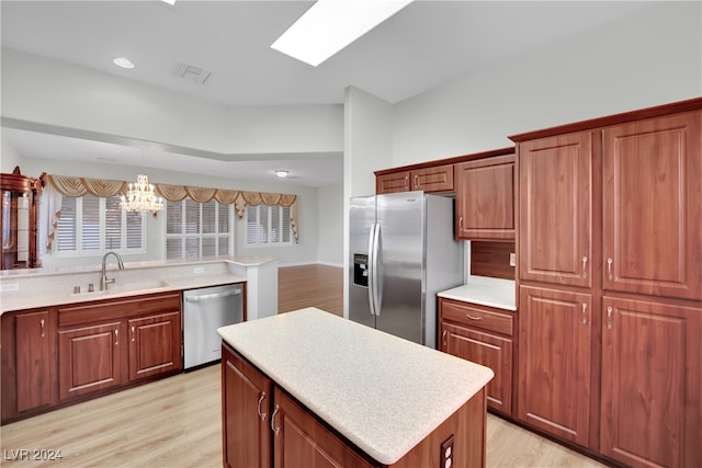 kitchen with pendant lighting, sink, appliances with stainless steel finishes, and light hardwood / wood-style flooring