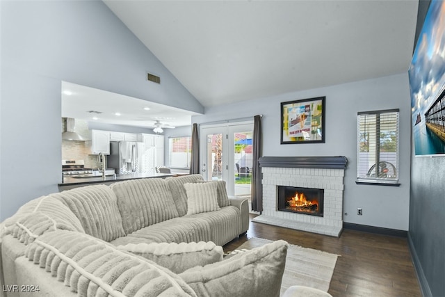 living room featuring hardwood / wood-style flooring, plenty of natural light, high vaulted ceiling, and a brick fireplace