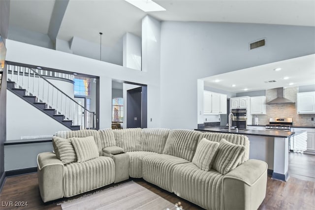 living room featuring sink, high vaulted ceiling, and hardwood / wood-style flooring