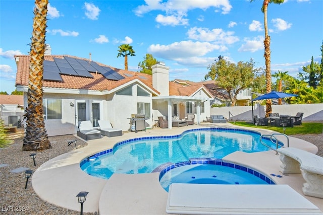 view of pool featuring an in ground hot tub, outdoor lounge area, a patio, and grilling area