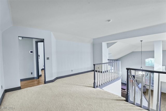 unfurnished room featuring carpet flooring, a chandelier, and lofted ceiling