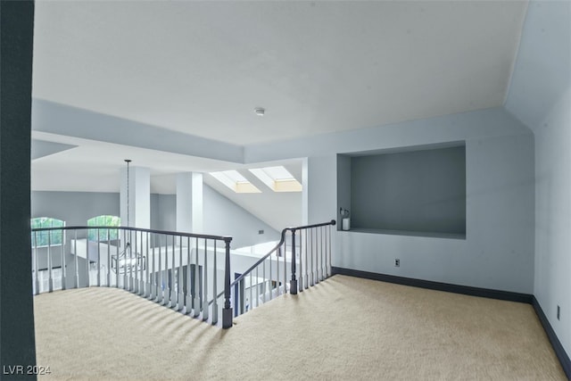 additional living space featuring carpet floors and lofted ceiling with skylight