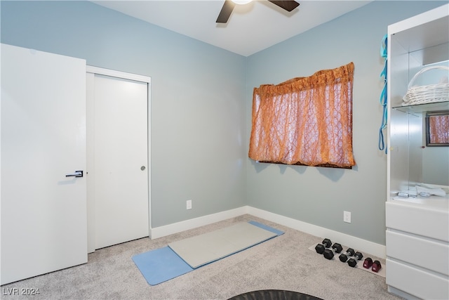 exercise area with light colored carpet and ceiling fan