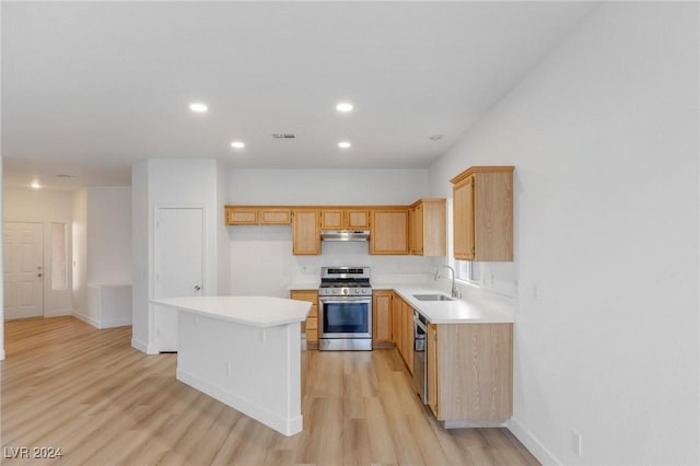 kitchen featuring under cabinet range hood, appliances with stainless steel finishes, light countertops, and a sink