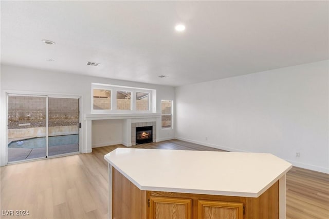 kitchen with a center island, open floor plan, light countertops, and light wood-style flooring