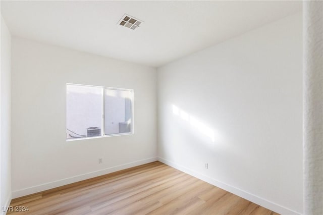 unfurnished room featuring light wood-type flooring, baseboards, and visible vents