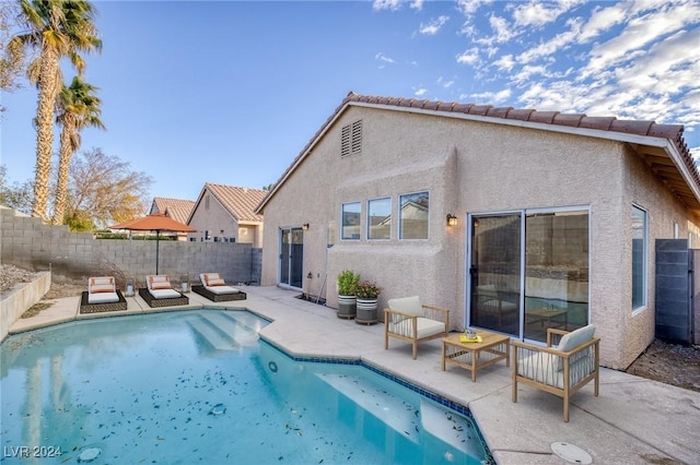 rear view of house featuring a patio area, a fenced backyard, a fenced in pool, and stucco siding