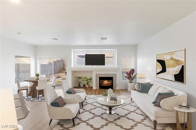 living area with light wood-style floors, visible vents, and a fireplace