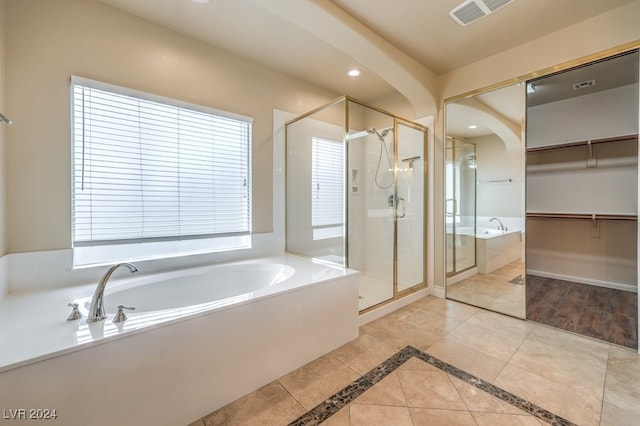 bathroom featuring tile patterned flooring and shower with separate bathtub