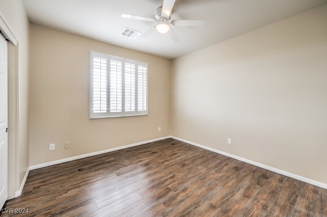 empty room with ceiling fan and dark hardwood / wood-style flooring